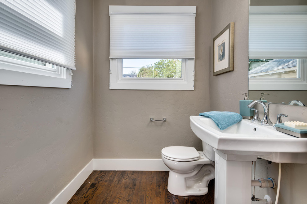 Immagine di una piccola stanza da bagno con doccia american style con WC a due pezzi, pareti grigie, parquet scuro e lavabo a colonna