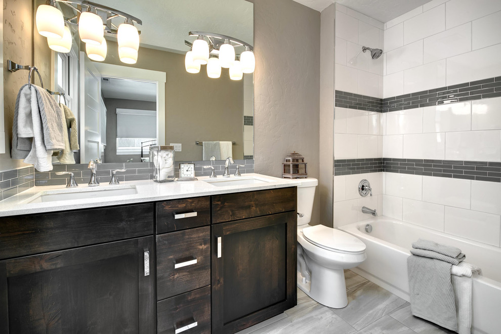 Cette photo montre une petite salle de bain principale craftsman en bois foncé avec un placard à porte shaker, une baignoire en alcôve, un combiné douche/baignoire, WC séparés, un carrelage blanc, des carreaux de porcelaine, un mur gris, un sol en carrelage de porcelaine, un lavabo encastré et un plan de toilette en granite.