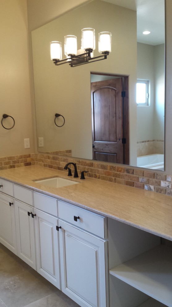 This is an example of a bathroom in Albuquerque with dark wood cabinets, beige tiles, stone tiles, porcelain flooring, a submerged sink and granite worktops.