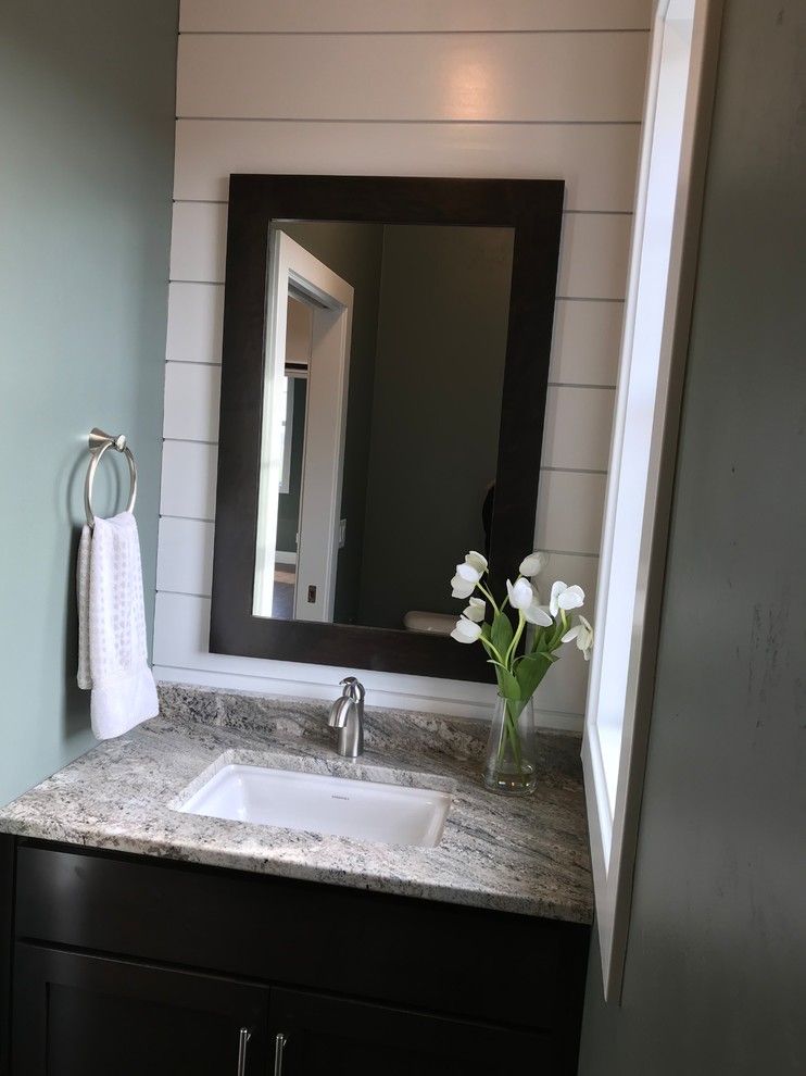 Cette image montre une petite salle de bain design en bois foncé avec un placard à porte shaker et un plan de toilette en granite.