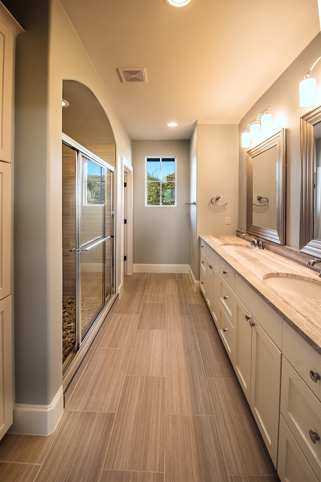 Inspiration for a large mediterranean kids' beige tile and porcelain tile porcelain tile double shower remodel in Austin with shaker cabinets, white cabinets, a two-piece toilet, white walls, an undermount sink and granite countertops