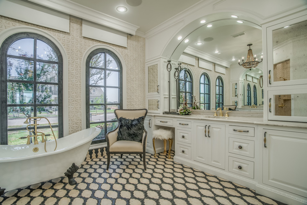 Стильный дизайн: большая главная ванная комната в классическом стиле с фасадами с выступающей филенкой, белыми фасадами, ванной на ножках, врезной раковиной и бежевыми стенами - последний тренд