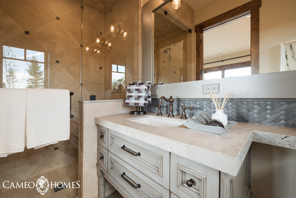 Cette image montre une grande salle de bain traditionnelle en bois vieilli avec un placard à porte affleurante, WC séparés, un carrelage gris, un mur blanc, un sol en carrelage de porcelaine, un lavabo encastré et un plan de toilette en stéatite.