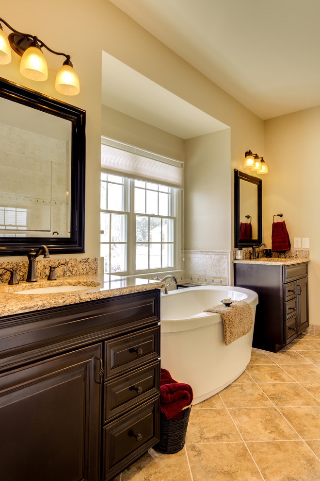Inspiration för mellanstora klassiska brunt en-suite badrum, med luckor med upphöjd panel, skåp i mörkt trä, ett fristående badkar, klinkergolv i porslin, ett undermonterad handfat, bänkskiva i kvarts och brunt golv