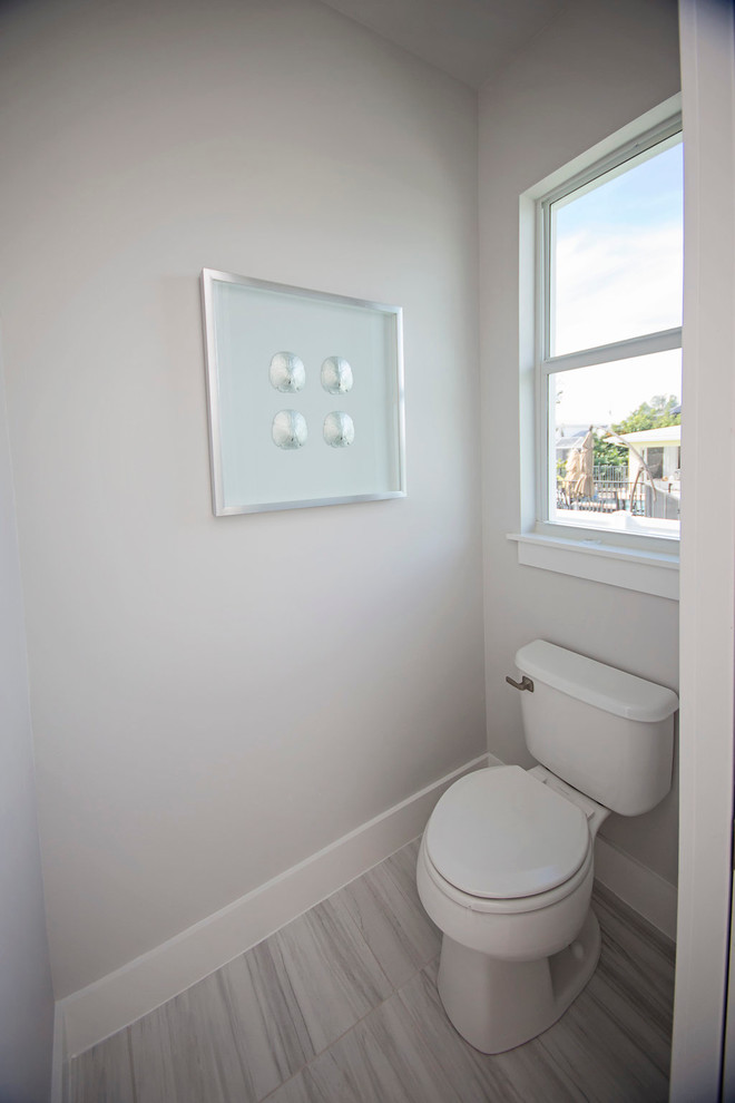 Idées déco pour un grand WC et toilettes moderne avec un placard avec porte à panneau encastré, des portes de placard grises, WC séparés, un carrelage gris, un carrelage blanc, un carrelage de pierre, un mur blanc, un sol en marbre, un lavabo encastré et un plan de toilette en marbre.