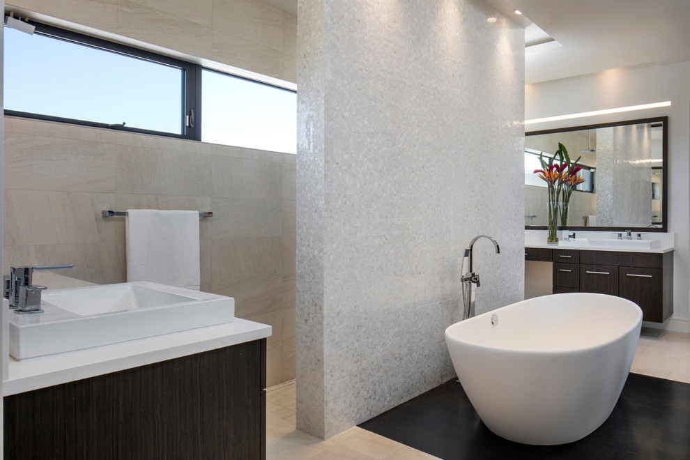 Стильный дизайн: главная ванная комната в современном стиле с темными деревянными фасадами, отдельно стоящей ванной, белой плиткой, плоскими фасадами, плиткой мозаикой, настольной раковиной, разноцветным полом и белой столешницей - последний тренд