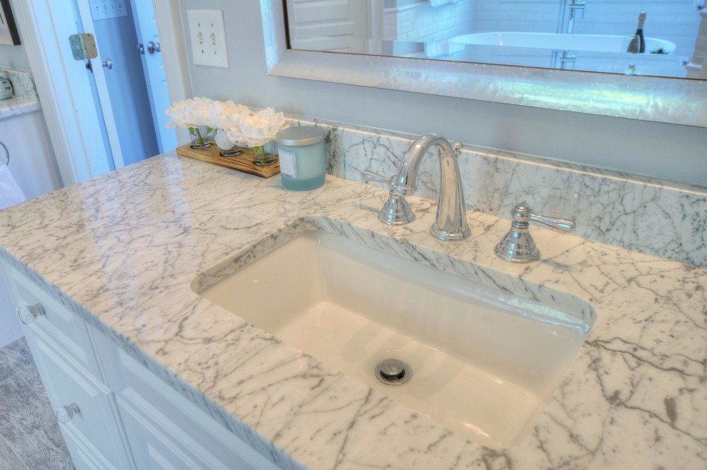 Example of a classic master white tile and subway tile white floor bathroom design in Other with shaker cabinets, white cabinets, a two-piece toilet, white walls, an undermount sink, marble countertops and a hinged shower door