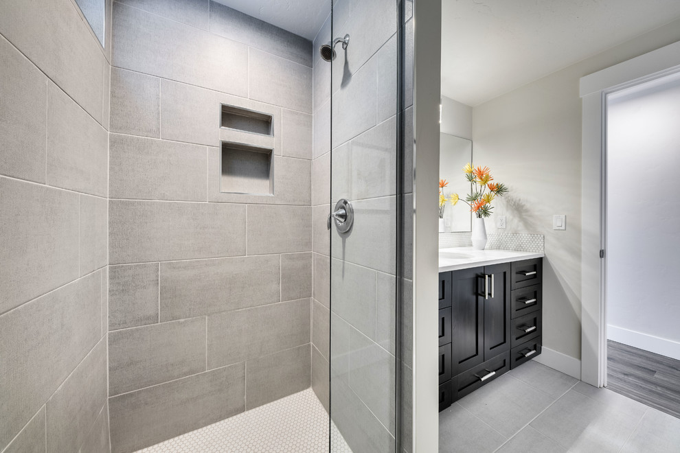 Example of a mid-sized trendy kids' white tile and ceramic tile ceramic tile and gray floor alcove shower design in Boise with shaker cabinets, dark wood cabinets, a two-piece toilet, white walls, an undermount sink, quartz countertops and a hinged shower door
