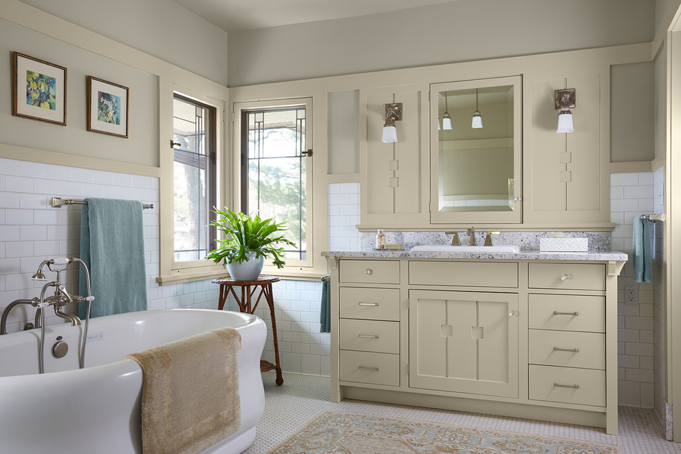 Пример оригинального дизайна: ванная комната в классическом стиле с плоскими фасадами, бежевыми фасадами, отдельно стоящей ванной, белой плиткой, плиткой кабанчик, серыми стенами, полом из мозаичной плитки, накладной раковиной, белым полом и серой столешницей