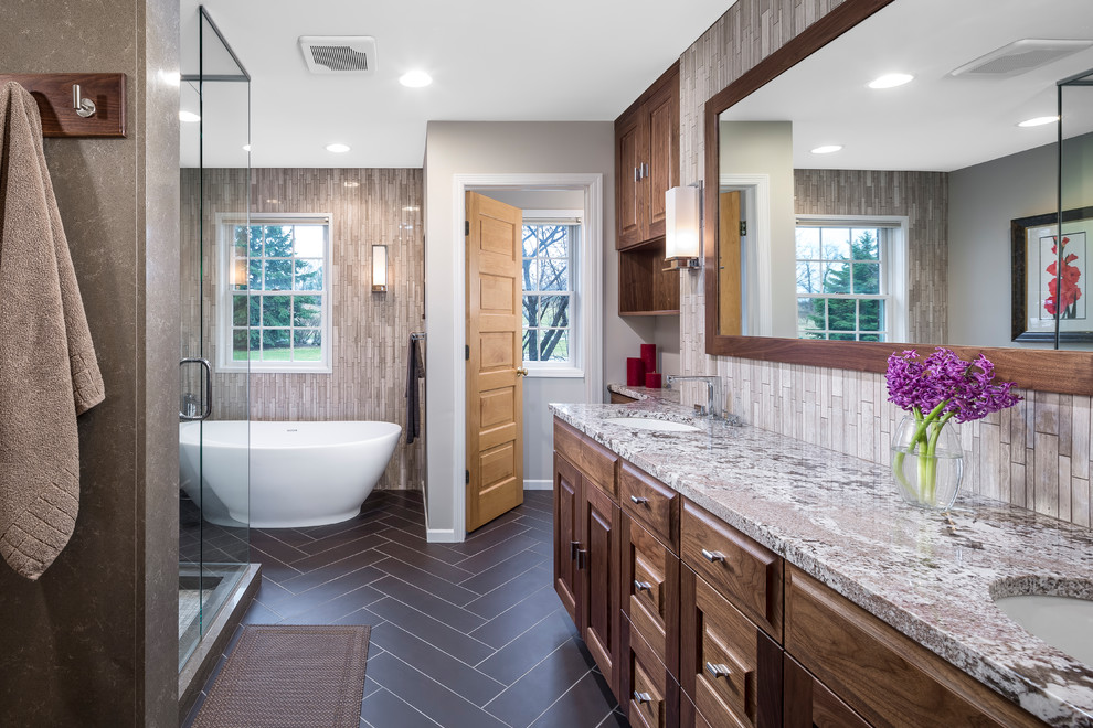 This is an example of a classic bathroom in Minneapolis with raised-panel cabinets, dark wood cabinets, a freestanding bath, a corner shower, beige tiles and a submerged sink.