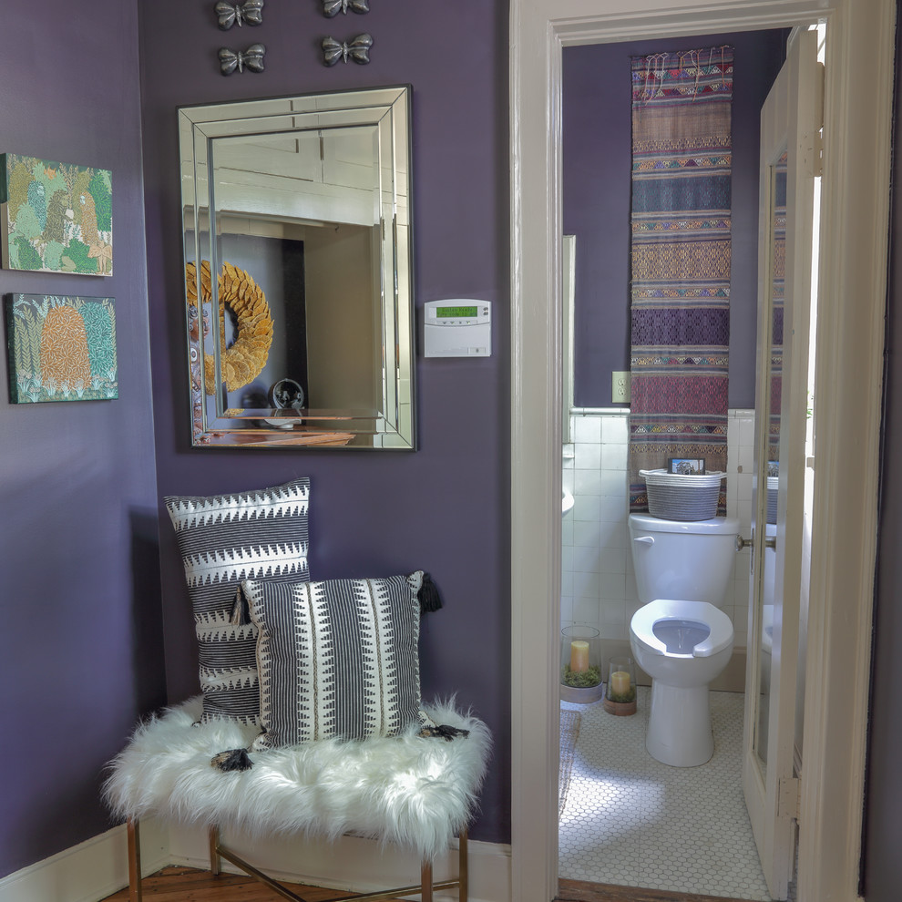 Immagine di una piccola stanza da bagno eclettica con ante a filo, ante beige, pareti viola, pavimento in legno massello medio e pavimento marrone