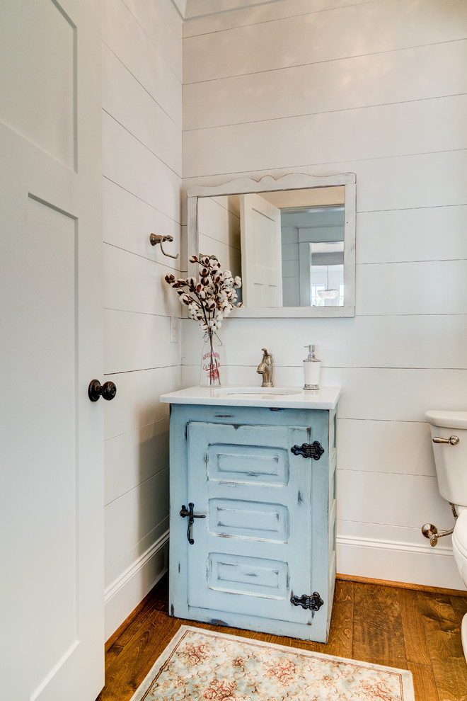 Inspiration for a mid-sized cottage medium tone wood floor and brown floor open shower remodel in Other with furniture-like cabinets, a one-piece toilet, white walls and marble countertops