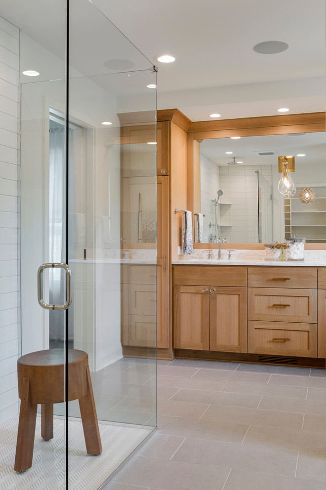 Inspiration for a medium sized traditional ensuite bathroom in Minneapolis with shaker cabinets, light wood cabinets, a corner shower, white walls, ceramic flooring, a submerged sink, marble worktops, grey floors, a hinged door and white worktops.