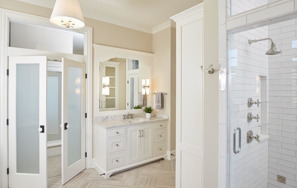 Пример оригинального дизайна: главная ванная комната в классическом стиле с белыми фасадами, душевой комнатой, белой плиткой, бежевыми стенами, накладной раковиной, мраморной столешницей, бежевым полом и душем с распашными дверями