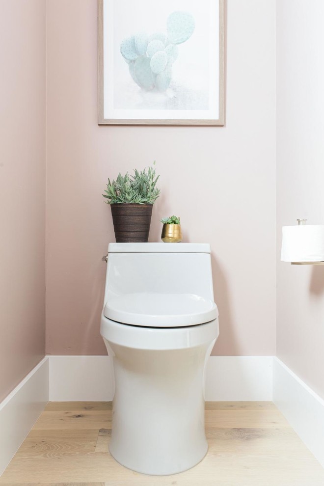 Immagine di un bagno di servizio design di medie dimensioni con ante lisce, ante grigie, WC monopezzo, pareti rosa, parquet chiaro, lavabo sottopiano, top in granito e pavimento beige