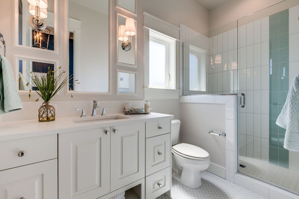 Design ideas for a medium sized classic shower room bathroom in Boise with raised-panel cabinets, white cabinets, an alcove shower, a two-piece toilet, blue tiles, white tiles, porcelain tiles, beige walls, mosaic tile flooring, a submerged sink, quartz worktops, white floors and a hinged door.