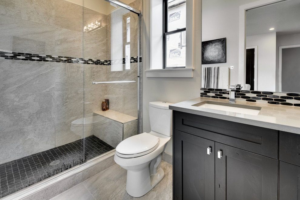 Idéer för att renovera ett mellanstort funkis badrum med dusch, med skåp i shakerstil, svarta skåp, en dusch i en alkov, en toalettstol med separat cisternkåpa, grå kakel, porslinskakel, vita väggar, klinkergolv i porslin, ett undermonterad handfat, bänkskiva i kvarts, grått golv och dusch med skjutdörr