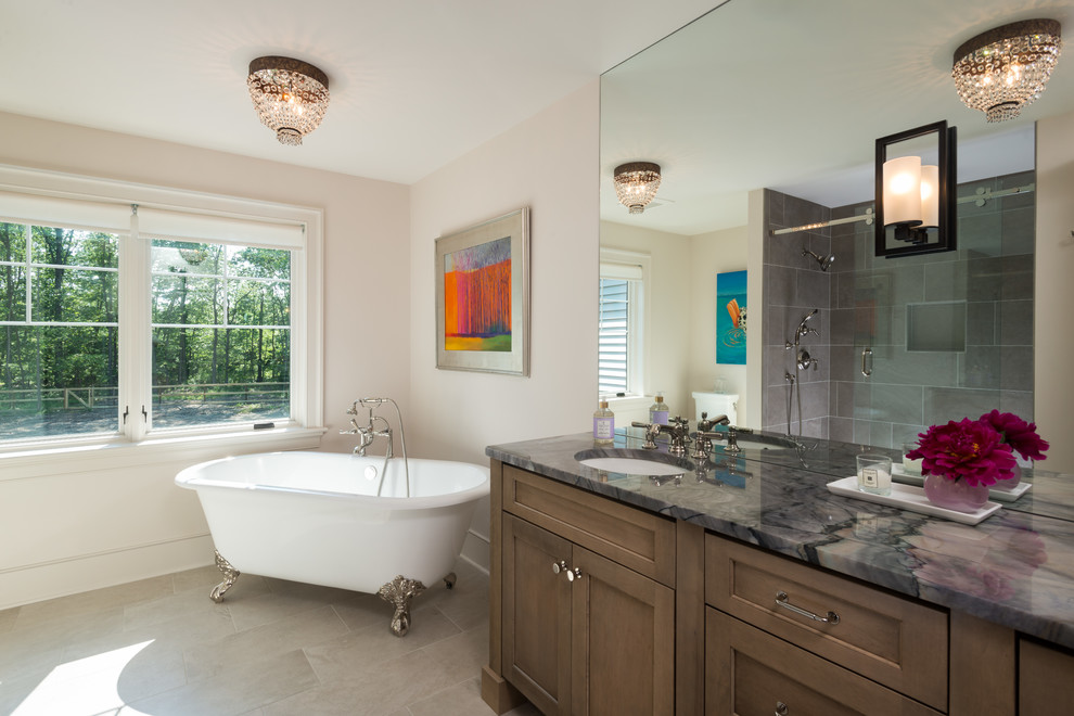 Photo of a large country ensuite bathroom in New York with a freestanding bath, a built-in shower, a two-piece toilet, white tiles, ceramic tiles, white walls, ceramic flooring, a submerged sink, beige floors, a sliding door, grey worktops, shaker cabinets, dark wood cabinets and granite worktops.