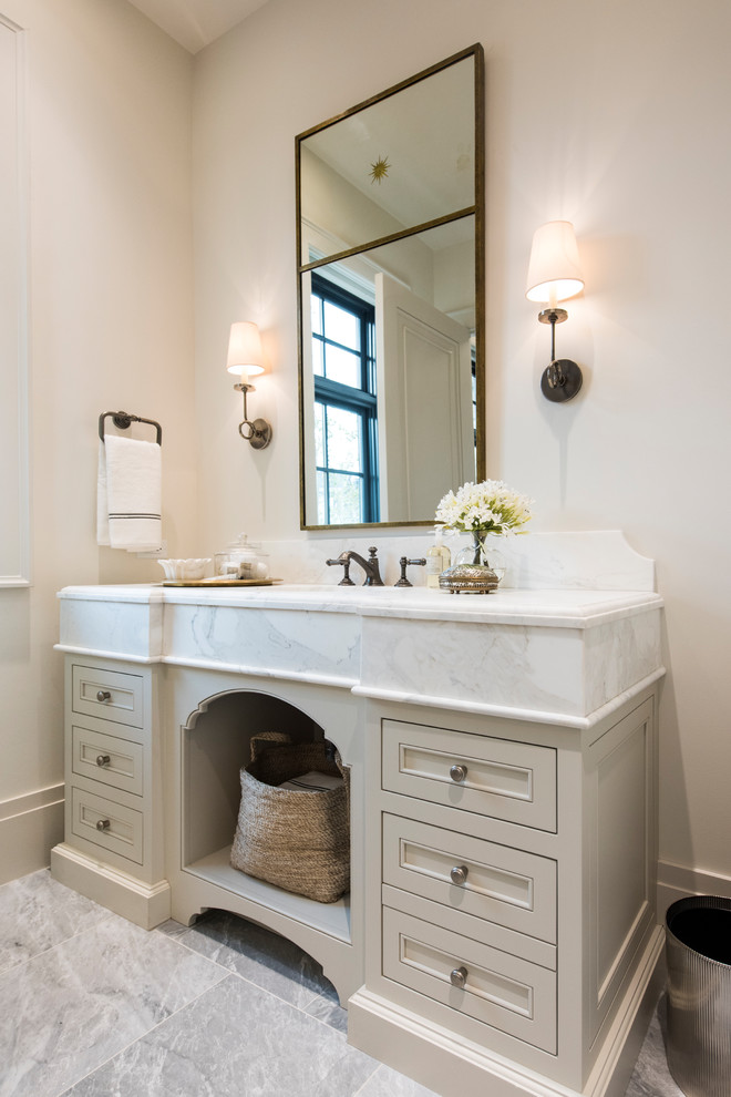 Inredning av ett klassiskt badrum med dusch, med beige skåp, beige väggar, ett undermonterad handfat, grått golv och luckor med infälld panel