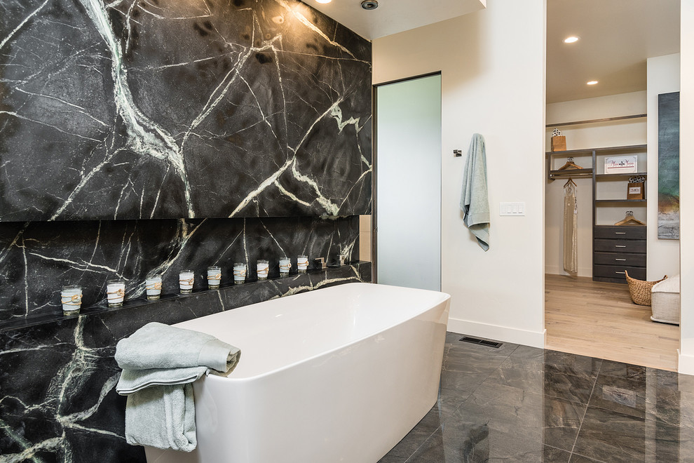 Cette image montre une salle de bain principale design avec une baignoire indépendante, une douche double, un carrelage blanc, des dalles de pierre, un mur blanc, un sol en carrelage de porcelaine, un sol gris et aucune cabine.
