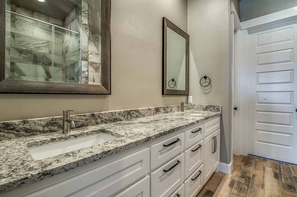 Bild på ett mellanstort vintage en-suite badrum, med skåp i shakerstil, vita skåp, ett badkar i en alkov, en dusch i en alkov, beige kakel, stenkakel, beige väggar, klinkergolv i porslin, ett undermonterad handfat, granitbänkskiva, beiget golv och dusch med gångjärnsdörr