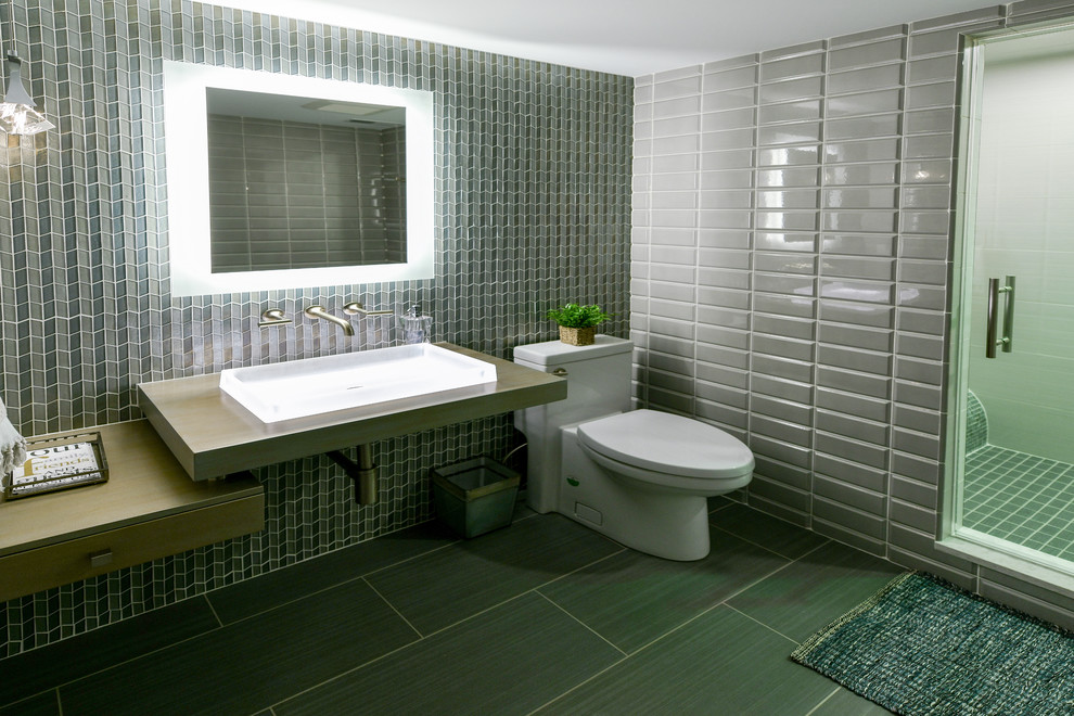 Idéer för att renovera ett mellanstort funkis beige beige badrum med dusch, med öppna hyllor, en dusch i en alkov, en toalettstol med hel cisternkåpa, grå kakel, keramikplattor, grå väggar, klinkergolv i porslin, ett nedsänkt handfat, grått golv och dusch med gångjärnsdörr