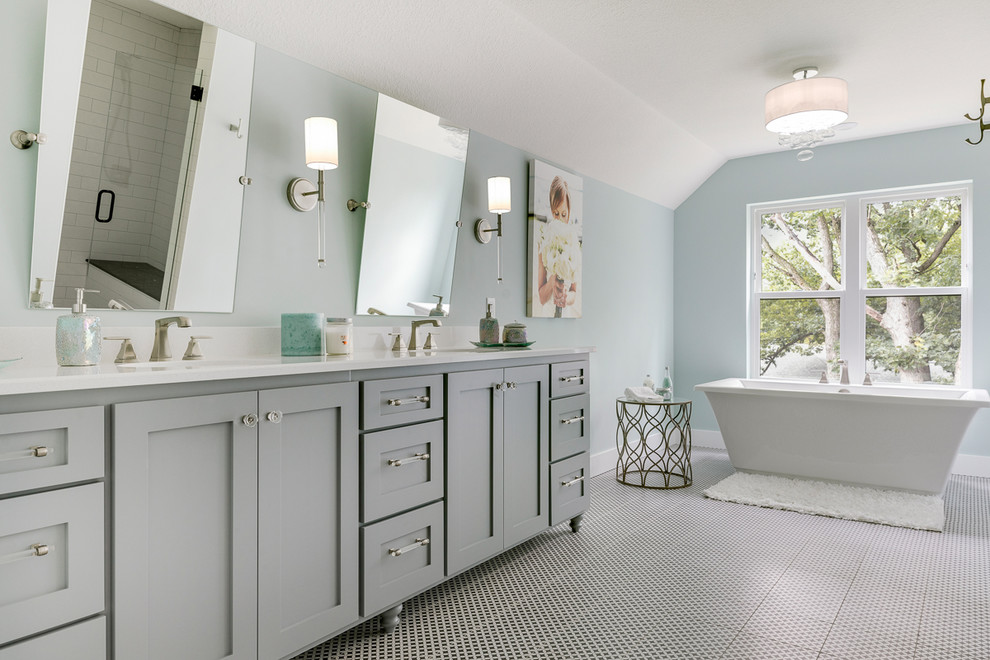 Свежая идея для дизайна: главная ванная комната в стиле неоклассика (современная классика) с серыми фасадами, отдельно стоящей ванной, синими стенами, полом из керамической плитки, столешницей из искусственного кварца, разноцветным полом, белой столешницей, фасадами в стиле шейкер и зеркалом с подсветкой - отличное фото интерьера