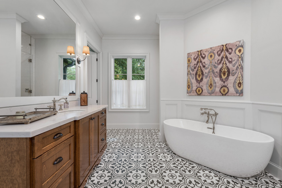 Exemple d'une salle de bain chic en bois brun avec un placard avec porte à panneau encastré, une baignoire indépendante, un mur blanc, carreaux de ciment au sol, un lavabo encastré, un sol multicolore, un plan de toilette blanc et du carrelage bicolore.