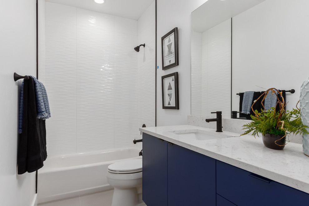Идея дизайна: ванная комната в современном стиле с плоскими фасадами, синими фасадами, ванной в нише, душем над ванной, белой плиткой, белыми стенами, врезной раковиной, бежевым полом, открытым душем и белой столешницей