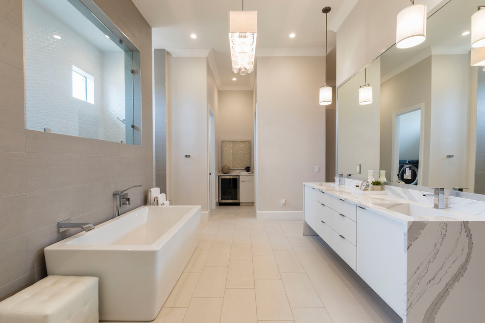 Design ideas for a contemporary ensuite bathroom in Orlando with flat-panel cabinets, white cabinets, a freestanding bath, beige walls, an integrated sink, beige floors and white worktops.