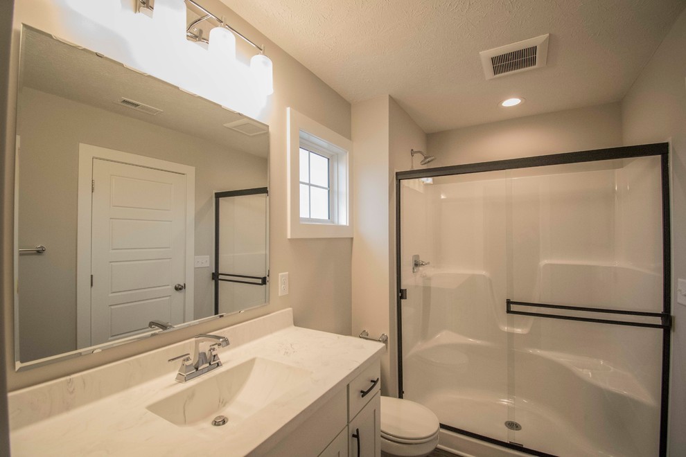 Стильный дизайн: большая главная ванная комната с фасадами с утопленной филенкой, белыми фасадами, душем в нише, унитазом-моноблоком, белой плиткой, мраморной плиткой, серыми стенами, полом из винила, монолитной раковиной, мраморной столешницей, коричневым полом, душем с раздвижными дверями и разноцветной столешницей - последний тренд