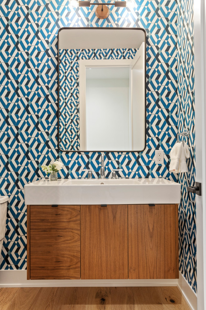 Foto de cuarto de baño contemporáneo de tamaño medio con armarios con paneles lisos, puertas de armario marrones, suelo de madera en tonos medios, lavabo integrado, suelo marrón y encimeras blancas