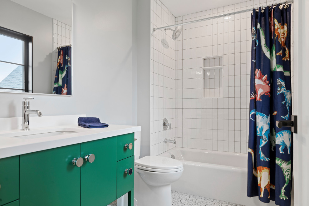 На фото: детская ванная комната среднего размера в современном стиле с плоскими фасадами, зелеными фасадами, ванной в нише, душем над ванной, раздельным унитазом, белой плиткой, керамической плиткой, белыми стенами, полом из керамической плитки, врезной раковиной, столешницей из искусственного кварца, разноцветным полом, шторкой для ванной и белой столешницей с