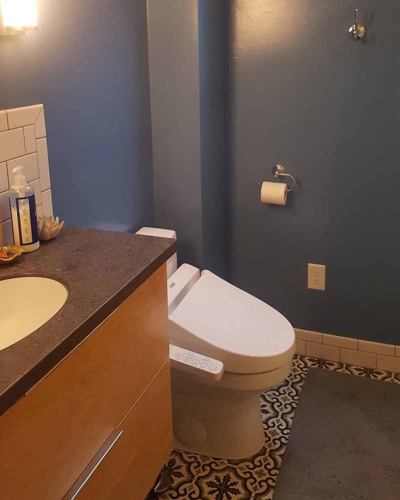 На фото: маленькая ванная комната в современном стиле с плоскими фасадами, светлыми деревянными фасадами, белой плиткой, плиткой кабанчик, синими стенами, полом из цементной плитки, врезной раковиной, разноцветным полом и черной столешницей для на участке и в саду с