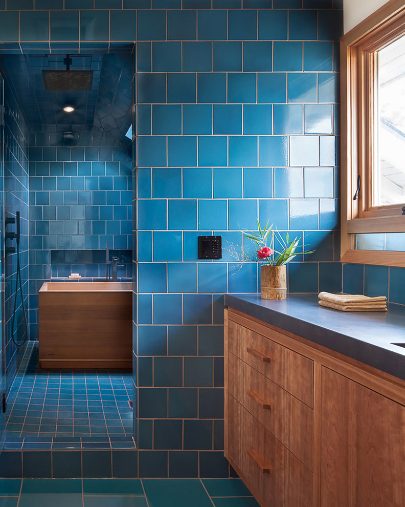 Идея дизайна: большая главная ванная комната в восточном стиле с плоскими фасадами, фасадами цвета дерева среднего тона, отдельно стоящей ванной, угловым душем, унитазом-моноблоком, синей плиткой, белыми стенами, полом из керамогранита, врезной раковиной, столешницей из бетона, синим полом, душем с распашными дверями и серой столешницей