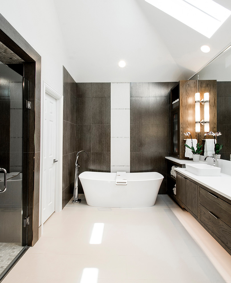 This is an example of a large contemporary ensuite bathroom in Dallas with flat-panel cabinets, medium wood cabinets, a freestanding bath, a built-in shower, beige tiles, white walls, a vessel sink, soapstone worktops, beige floors, a hinged door and white worktops.