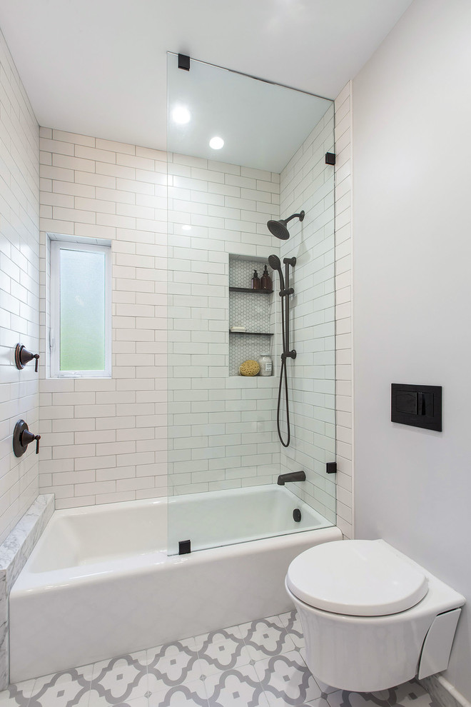 Klassisk inredning av ett mellanstort vit vitt badrum, med släta luckor, vita skåp, ett badkar i en alkov, en dusch/badkar-kombination, en vägghängd toalettstol, vit kakel, keramikplattor, grå väggar, klinkergolv i porslin, ett undermonterad handfat, flerfärgat golv och med dusch som är öppen
