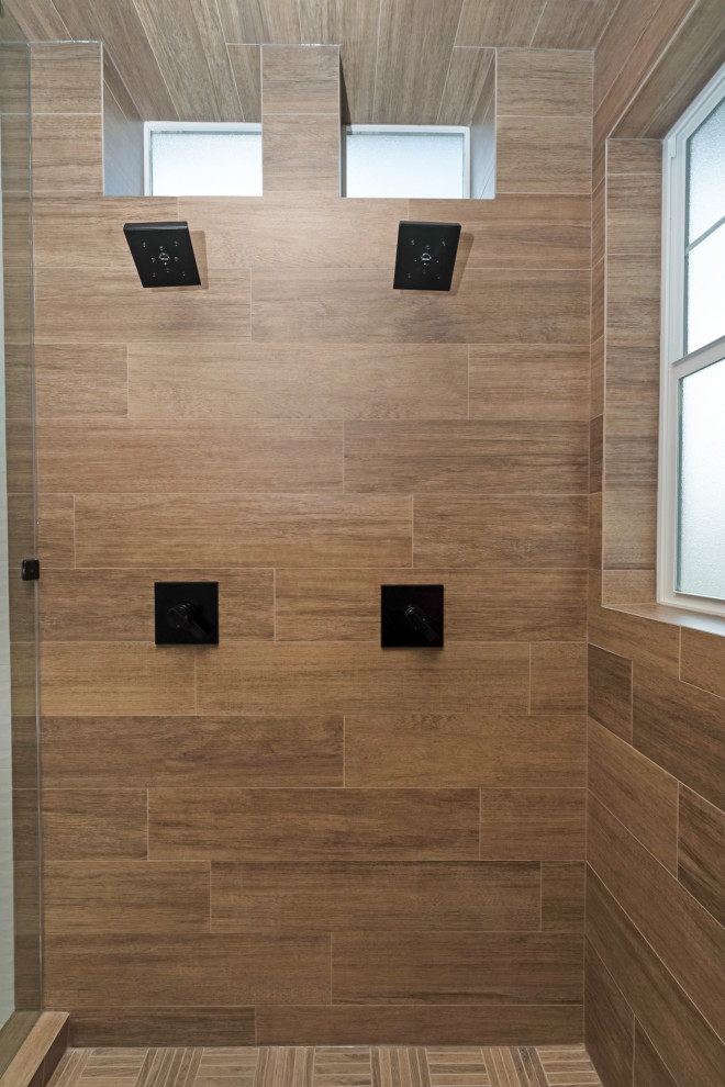 Стильный дизайн: большая главная ванная комната в стиле кантри с плоскими фасадами, светлыми деревянными фасадами, отдельно стоящей ванной, угловым душем, коричневой плиткой, керамогранитной плиткой, серыми стенами, полом из керамогранита, врезной раковиной, столешницей из искусственного кварца, белым полом, душем с распашными дверями и белой столешницей - последний тренд