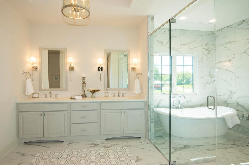 Inspiration for a large traditional ensuite wet room bathroom in Milwaukee with freestanding cabinets, grey cabinets, a freestanding bath, a two-piece toilet, grey tiles, marble tiles, white walls, marble flooring, a submerged sink, engineered stone worktops, grey floors, a hinged door and white worktops.