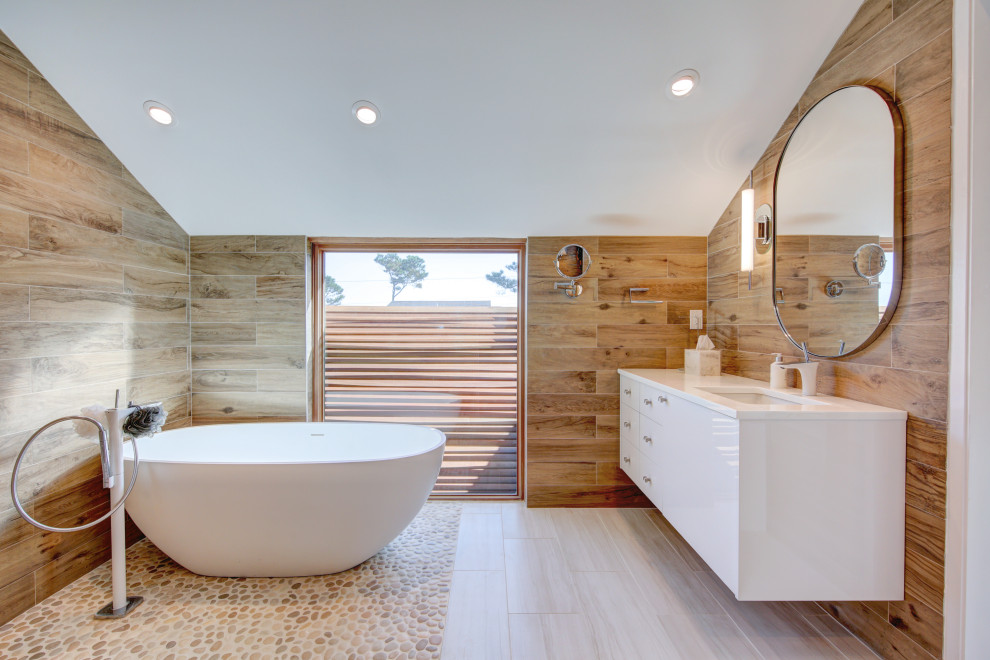 Пример оригинального дизайна: главная ванная комната в современном стиле с плоскими фасадами, белыми фасадами, отдельно стоящей ванной, коричневыми стенами, врезной раковиной, коричневым полом, белой столешницей, плиткой под дерево и сводчатым потолком
