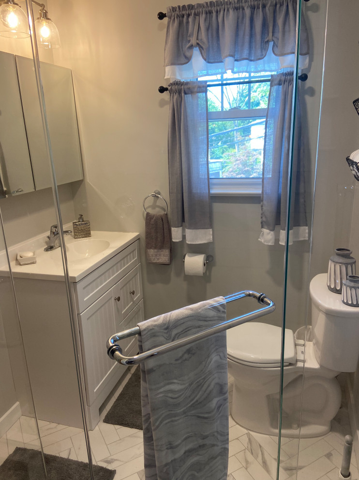 Aménagement d'une salle de bain classique avec des portes de placard blanches, une douche d'angle, un plan de toilette blanc et meuble simple vasque.