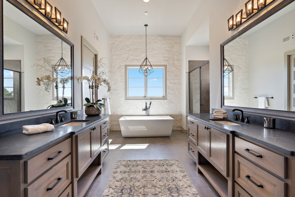 Large cottage master porcelain tile, gray floor and double-sink bathroom photo in Austin with shaker cabinets, gray cabinets, a two-piece toilet, gray walls, an undermount sink, granite countertops, a hinged shower door, black countertops and a built-in vanity
