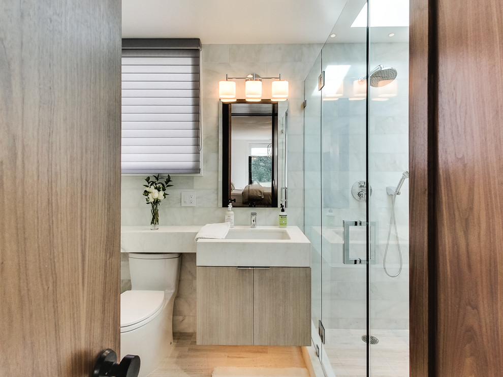 サンフランシスコにあるコンテンポラリースタイルのおしゃれな浴室 (アンダーカウンター洗面器、フラットパネル扉のキャビネット、淡色木目調キャビネット、アルコーブ型シャワー、一体型トイレ	、白いタイル、無垢フローリング) の写真