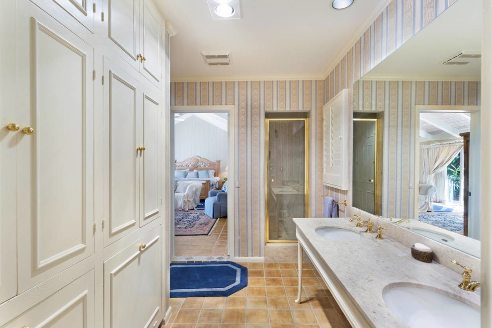 Свежая идея для дизайна: главная ванная комната среднего размера в морском стиле с фасадами с выступающей филенкой, бежевыми фасадами, душевой комнатой, унитазом-моноблоком, разноцветными стенами, полом из терракотовой плитки, врезной раковиной, мраморной столешницей, разноцветным полом, душем с распашными дверями и бежевой столешницей - отличное фото интерьера
