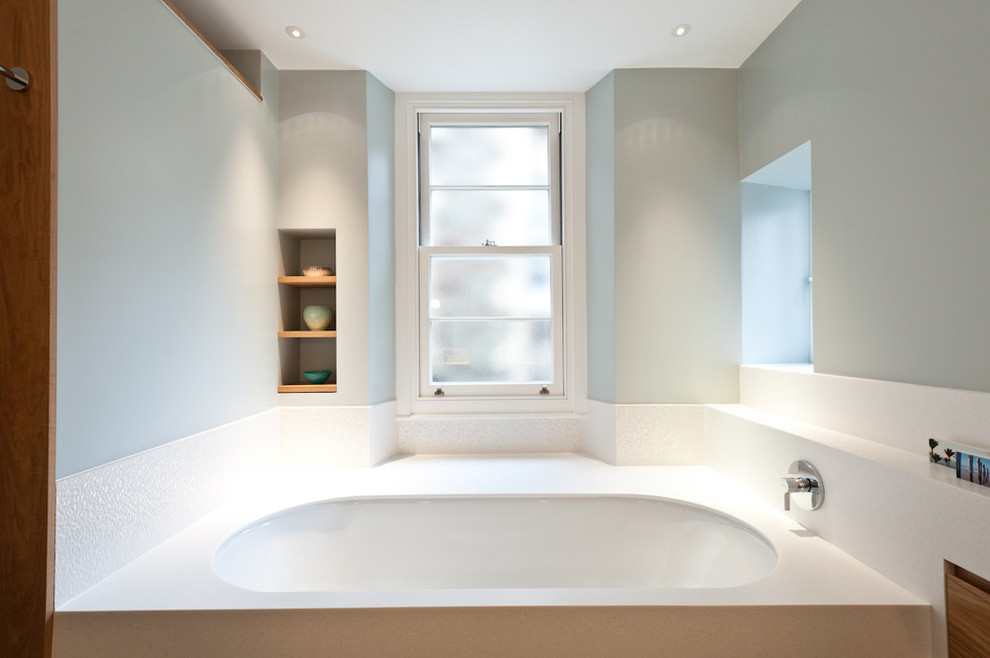 Idées déco pour une salle de bain contemporaine avec une baignoire encastrée et un carrelage blanc.