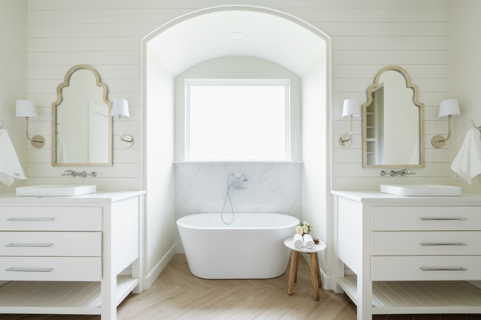 Design ideas for a classic bathroom in Oklahoma City with flat-panel cabinets, white cabinets, a freestanding bath, white walls, light hardwood flooring, a built-in sink, beige floors, white worktops, double sinks, a freestanding vanity unit and tongue and groove walls.
