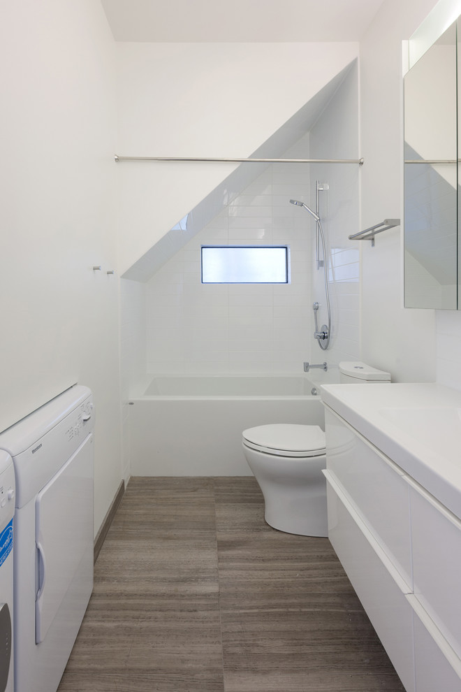 Foto på ett funkis badrum med dusch, med släta luckor, vita skåp, ett badkar i en alkov, en dusch/badkar-kombination, vit kakel, ett integrerad handfat, bänkskiva i kvarts, keramikplattor, vita väggar och klinkergolv i keramik