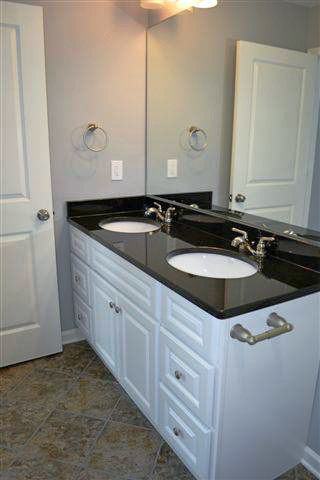 Example of a mid-sized trendy master multicolored tile and stone tile slate floor bathroom design in Other with an undermount sink, raised-panel cabinets, white cabinets, granite countertops, a one-piece toilet and gray walls