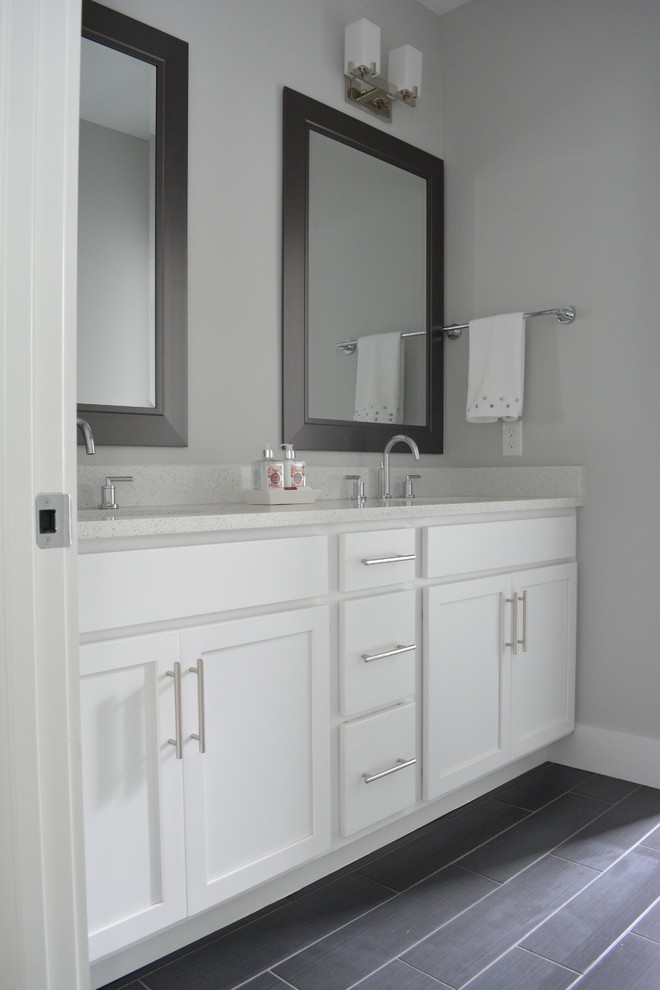 Foto på ett mellanstort badrum, med ett undermonterad handfat, skåp i shakerstil, vita skåp, bänkskiva i återvunnet glas, brun kakel, keramikplattor, grå väggar och klinkergolv i porslin