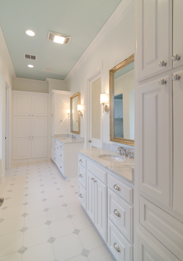 Modelo de cuarto de baño principal clásico extra grande con lavabo encastrado, armarios con paneles con relieve, puertas de armario blancas, encimera de granito, combinación de ducha y bañera y paredes blancas